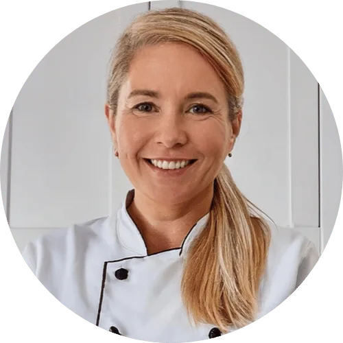 About me jessica -An American blonde female, age 40, with a warm and friendly expression, standing in a moder